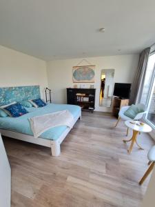 een slaapkamer met een bed en een woonkamer bij B&B de Koepeltjes in Zoetermeer