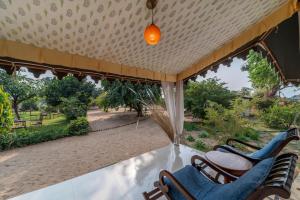a porch with chairs and a view of a park at Atithi Camp & Resort in Pushkar
