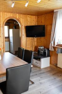 a dining room with a table and a tv on the wall at Bahnhöfle Ferienhaus in Stubersheim