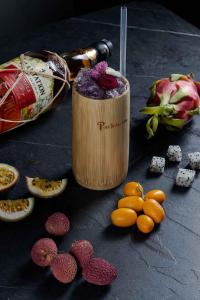 una bebida en un recipiente de madera junto a una fruta en ONOMA Hotel en Tesalónica