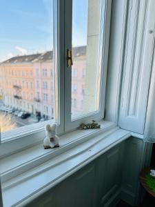 a white teddy bear sitting on a window sill at Danube Panorama apartments in Budapest