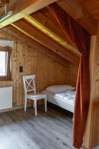 a bedroom with a bed and a chair in a room at Bahnhöfle Ferienhaus in Stubersheim