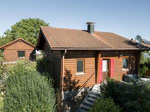 a small wooden house with a red door at Bahnhöfle Ferienhaus in Stubersheim