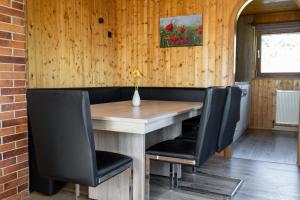 a wooden table with black chairs and a vase on it at Bahnhöfle Ferienhaus in Stubersheim