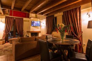 Monte Bianco Villas في أراخوفا: غرفة معيشة مع أريكة وطاولة
