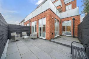 a brick building with a patio with two benches at Amazing 3 Bedroom Flat in the Heart of Wimbledon in London