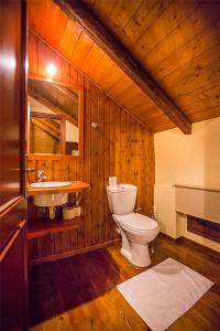 a wooden bathroom with a toilet and a sink at Monte Bianco Villas in Arachova