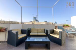 a patio with two chairs and a coffee table at Spacious 2BR home with Large, Private Sun Terrace by 360 Estates in Taʼ Xbiex