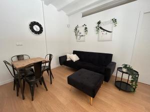 uma sala de estar com um sofá preto e uma mesa em Barceloneta beach house em Barcelona