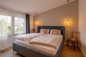 a bedroom with a large bed and a window at Adenauer Zwölf - Das 5 Sterne Ferienhaus mit Sauna und Garten am Eifelsteig in Kerpen