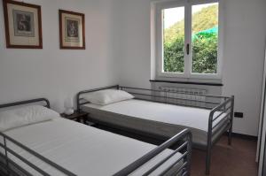 two beds in a room with a window at Rossola House in Bonassola