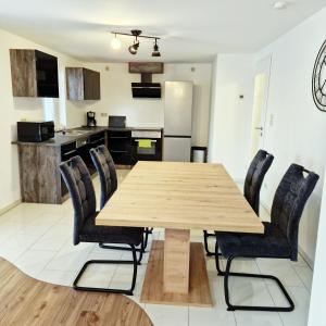 ein Esszimmer mit einem Holztisch und Stühlen in der Unterkunft DM Hotels & Apartments - Apartment Pfarrgasse 09 in Küllstedt