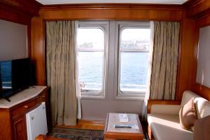 una sala de estar con una gran ventana en un barco en Nile Cruise Luxor Aswan 3,4 and 7 nights, en Asuán