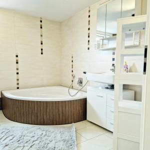 y baño con bañera y lavamanos. en DM Hotes & Apartments - Apartment Pfarrgasse 09, en Küllstedt