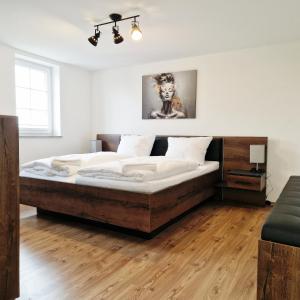 ein Schlafzimmer mit einem großen Bett in einem Zimmer in der Unterkunft DM Hotels & Apartments - Apartment Pfarrgasse 09 in Küllstedt