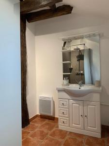 La salle de bains est pourvue d'un lavabo blanc et d'un miroir. dans l'établissement La Glatine - Chambres d'hôtes, à Frétigny