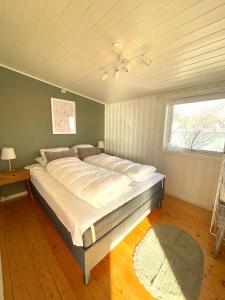 duże łóżko w pokoju z oknem w obiekcie Hytte i Svolvær w mieście Svolvær