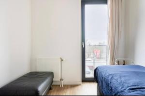 a bedroom with a bed and a large window at 4-bedroom large spacious apartment in Amsterdam
