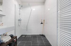 een douchecabine in een badkamer met een tegelvloer bij 4-bedroom large spacious apartment in Amsterdam