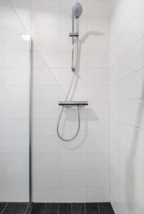um chuveiro com uma cabeça de chuveiro numa parede de azulejos brancos em 4-bedroom large spacious apartment em Amesterdão
