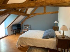 - une chambre avec un lit et du parquet dans l'établissement La Glatine - Chambres d'hôtes, à Frétigny