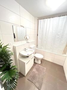 uma casa de banho branca com um WC e um lavatório em City Appartement direkt am Schloss! em Karlsruhe