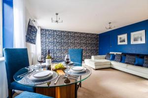 a blue living room with a table and a couch at Sapphire Retreat - Central Location - Free Parking, FastWiFi and Smart TV by Yoko Property in Derby