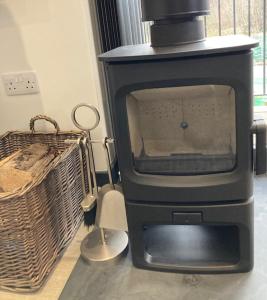 a fireplace with a tv and a basket in a room at Tigh Na Beithe in North Ballachulish