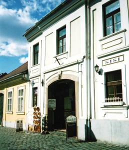 a white building with a door on a street at Arany Barokk Apartman in Eger