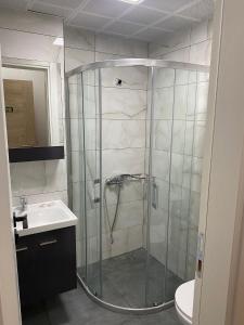 een douche met een glazen deur in de badkamer bij Unver Holiday Homes in Marmaris