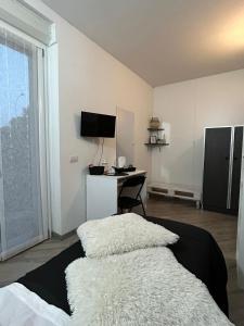 um quarto com uma cama e uma secretária com uma televisão em BeB Casa di Lia em Carugo