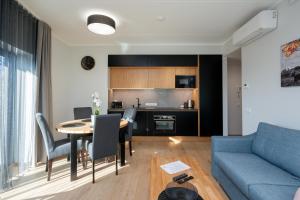 Una sala de estar con una mesa y un sofá azul. en TartuKodu Riia 22-24, en Tartu