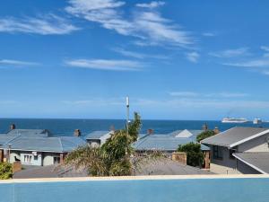 a view of houses and the ocean with a cruise ship at Suidersee Block 2, Hartenbos in Hartenbos