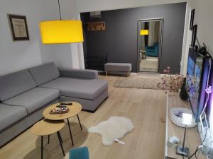 Home apartment في نيشْ: غرفة معيشة مع أريكة وطاولة