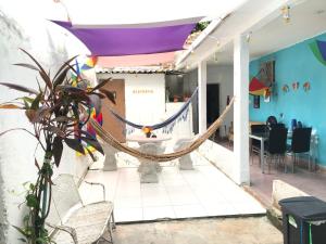 a room with a hammock and a table and chairs at Lê'Frevo Pernambucano Hostel in Recife