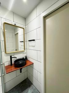 ein Bad mit einem Waschbecken und einem Spiegel in der Unterkunft Barceloneta beach house in Barcelona