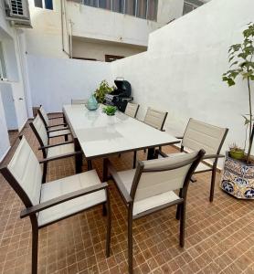 Una mesa blanca y sillas en un patio. en UIM Mediterraneo PB Miguel Hernandez Wifi, en Puerto Sagunto