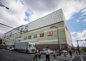 京都市にあるカモンイン 東寺東の建物前の道を横断する人々