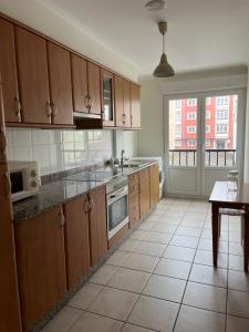 a kitchen with wooden cabinets and a tile floor at Casa das Sereas in Laxe +10 photos