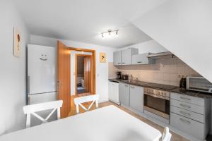 uma cozinha com electrodomésticos brancos e armários brancos em Gemütliche Wohnung mit Küche in ruhiger Lage em Adelheidsdorf