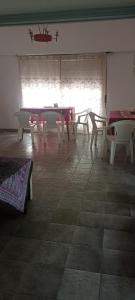 Habitación con mesas, sillas y ventana en Hostel Dakini en Lomas de Zamora