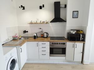 a kitchen with white cabinets and a stove top oven at Home apartment in Niš
