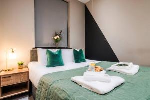 Un dormitorio con una cama verde y blanca con toallas en Wiverton Apt #2 - Central Location - Free Parking, Fast WiFi and Smart TV by Yoko Property, en Nottingham