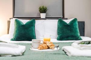 un vassoio di croissant e succo d'arancia su un letto di Wiverton Apt #2 - Central Location - Free Parking, Fast WiFi and Smart TV by Yoko Property a Nottingham