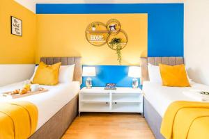 2 camas en una habitación de color amarillo y azul en Brook Retreat - City Centre - Free Parking, Fast WiFi and Smart TV by Yoko Property en Derby