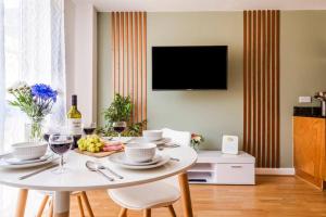 a white table with a plate of food and wine glasses at Brook Retreat - City Centre - Free Parking, Fast WiFi and Smart TV by Yoko Property in Derby