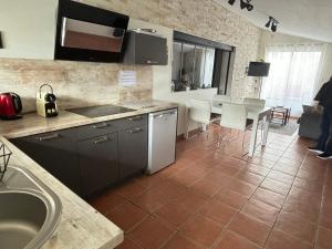 a kitchen with a sink and a table with white chairs at appart central et son parking privatif gratuit in Collioure