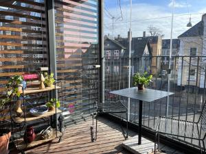 balkon ze stołem i widokiem na miasto w obiekcie Central family home in award-winning architecture w Kopenhadze