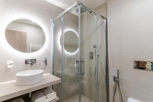 a bathroom with a glass shower and a sink at Spa & Wellness Hotel Fitak**** in Liptovský Ján