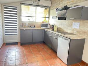 une cuisine avec des placards gris et un comptoir dans l'établissement appart central et son parking privatif gratuit, à Collioure